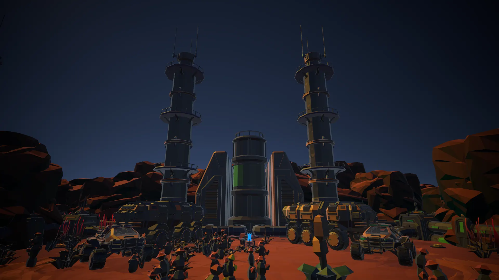 Twin industrial towers over red desert at night.